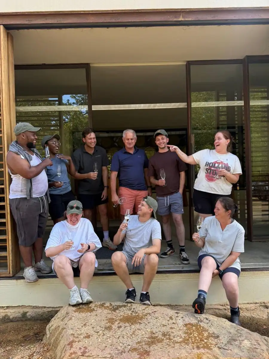 The group standing on the cellar step with glasses