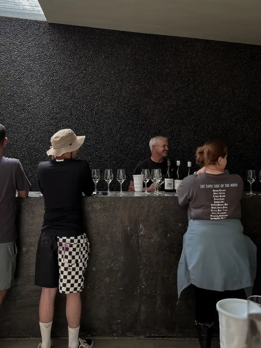 Tasting at a concrete counter against a black pebble wall